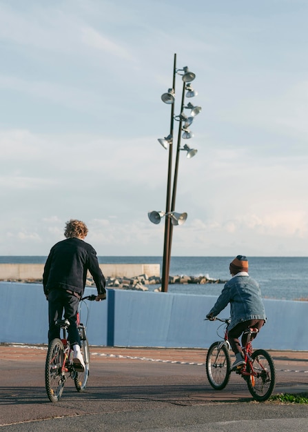 Vista posterior de los amigos del niño al aire libre en bicicletas