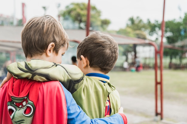 Vista posterior de dos niños en traje de superhéroe