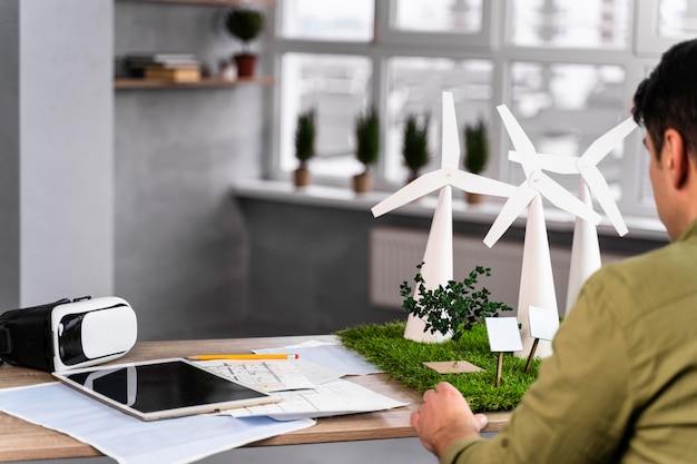 Foto gratuita vista posterior del hombre que trabaja en un proyecto de energía eólica ecológica