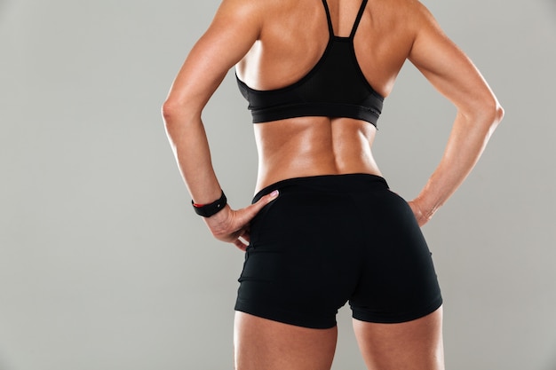 Vista posterior de la imagen recortada de una mujer muscular sana