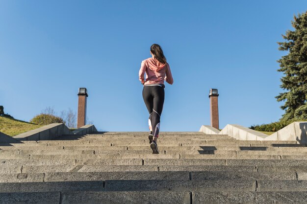 Vista posterior joven atleta corriendo al aire libre