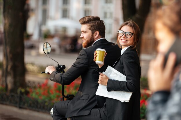 Vista posterior de la joven pareja despreocupada elegante monta en moto