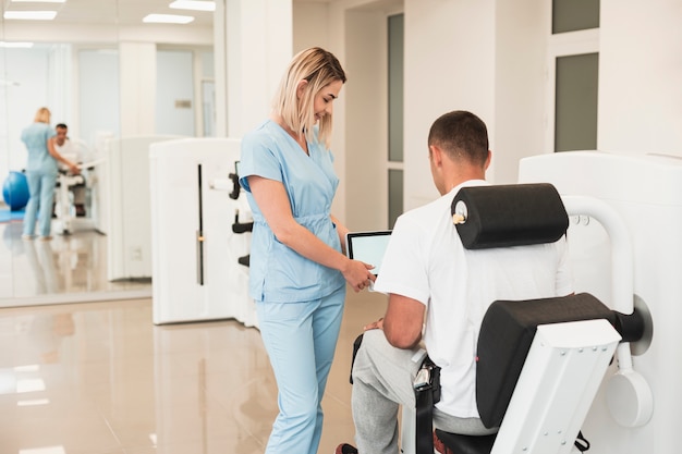 Vista posterior médico ayudando al paciente con un ejercicio médico