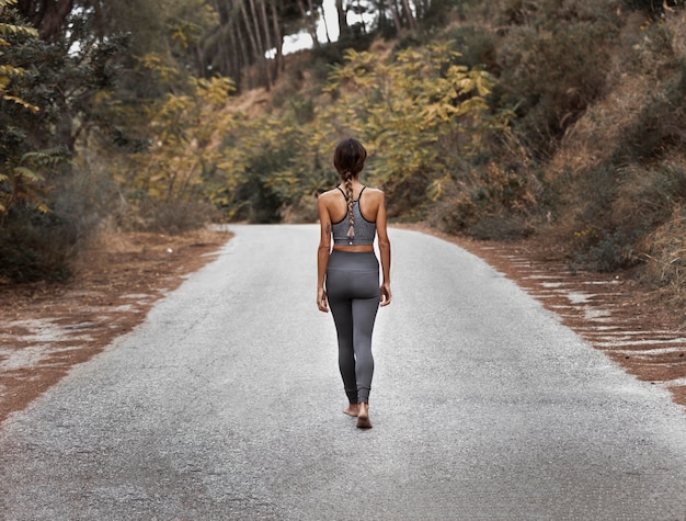 Foto gratuita vista posterior de la mujer en la carretera haciendo yoga