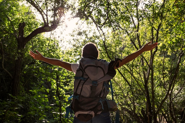 Foto gratuita vista posterior de la mujer despreocupada en la naturaleza con mochila