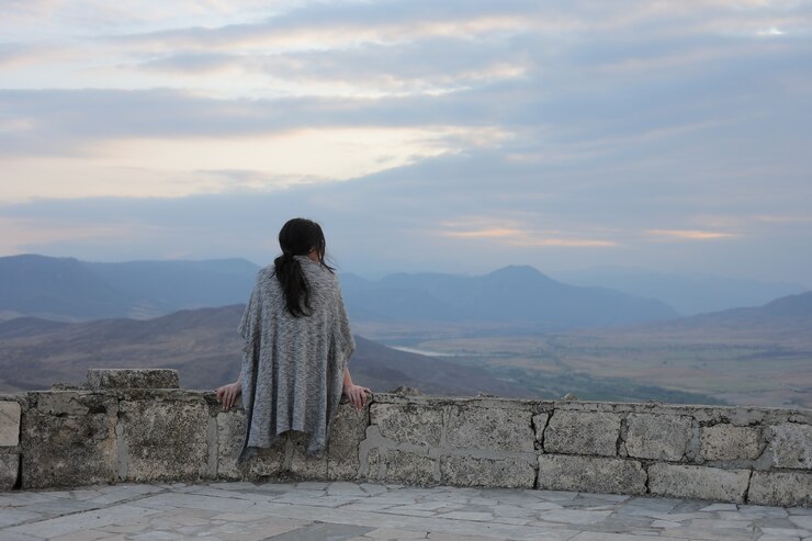 Foto gratuito vista posterior de una mujer joven admirando la belleza de las montañas en karabaj