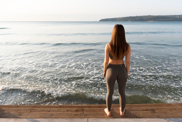 Vista posterior mujer mirando al mar con espacio de copia