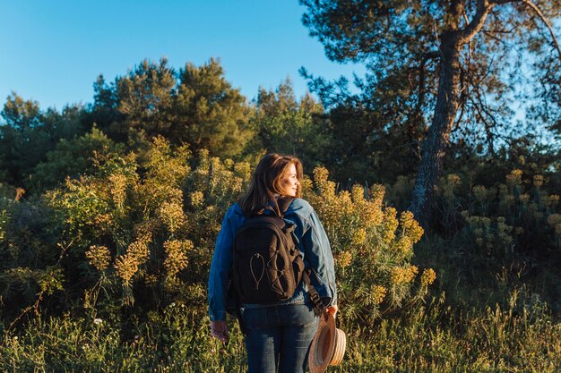 Vista posterior de mujer con mochila en la naturaleza