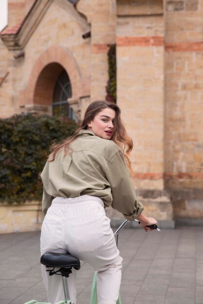 Vista posterior de la mujer montando bicicleta en la ciudad