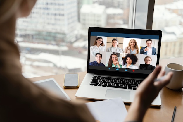 Vista posterior de la mujer que tiene una videollamada en el trabajo