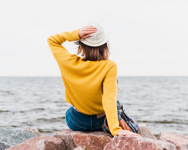 Foto gratuita vista posterior de la mujer que viaja frente al océano