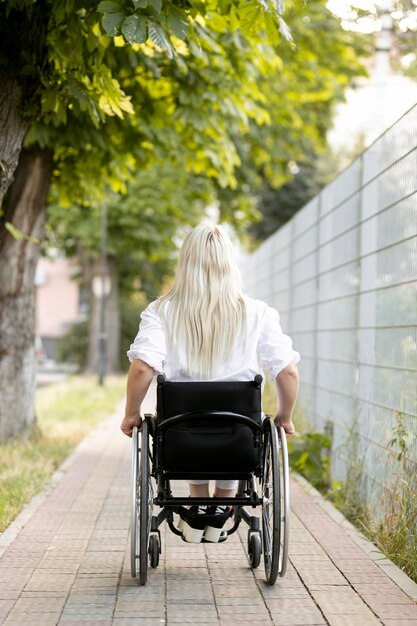 Vista posterior de la mujer en silla de ruedas en la ciudad