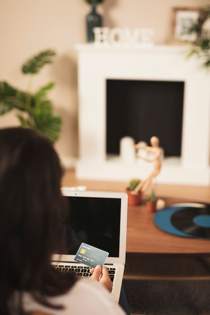 Foto gratuita vista posterior mujer sosteniendo una tarjeta de crédito