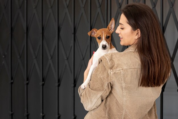 Vista posterior de la mujer con su perro afuera