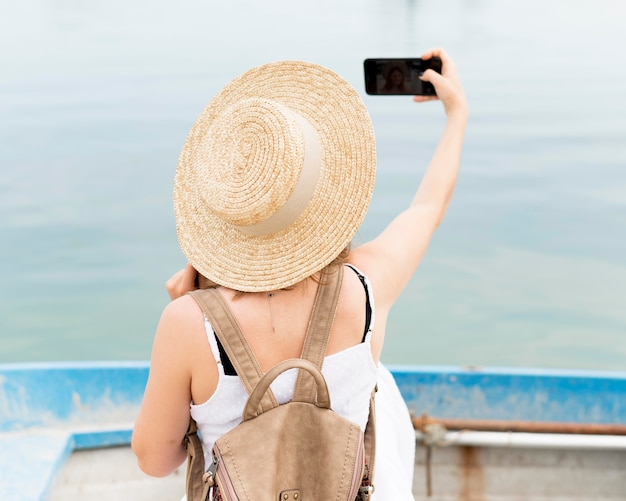 Vista posterior mujer tomando selfie