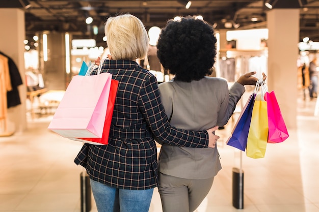 Foto gratuita vista posterior de mujeres adultas con bolsas de compras