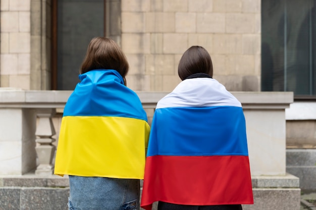 Foto gratuita vista posterior de mujeres con bandera rusa y ucraniana