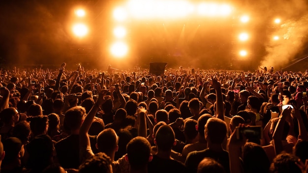 Vista posterior de la multitud de fans viendo actuaciones en directo en un concierto de música por la noche Copiar espacio