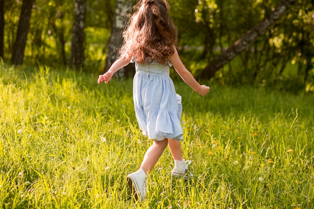 Vista posterior de una niña corriendo en el parque