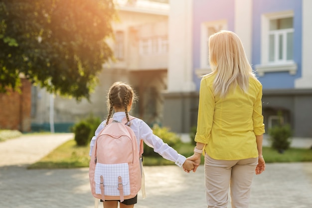 Foto gratuita vista posterior niña tomados de la mano con madre