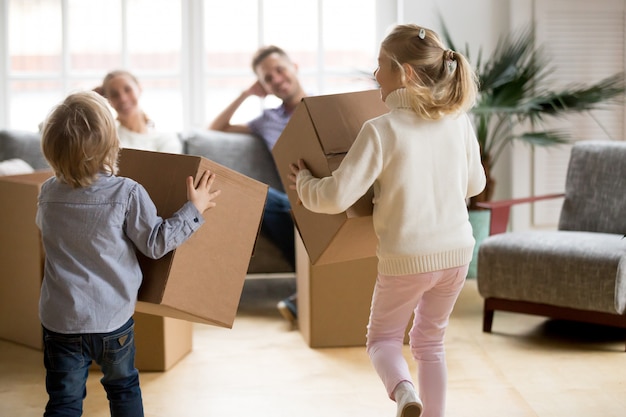 Vista posterior a los niños jugando con cajas en días en movimiento