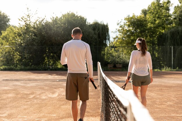 Vista posterior pareja en cancha de tenis