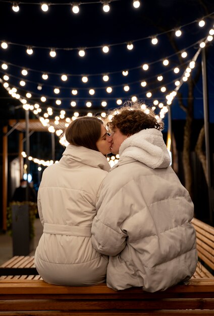 Vista posterior de la pareja de pie al aire libre con luces