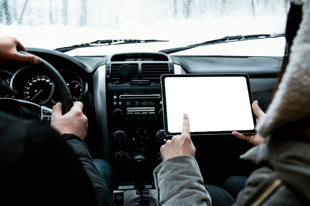 Vista posterior de la pareja en la tableta de consulta de coche durante un viaje por carretera