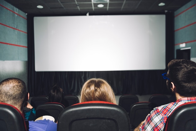 Vista posterior personas mirando la pantalla de cine