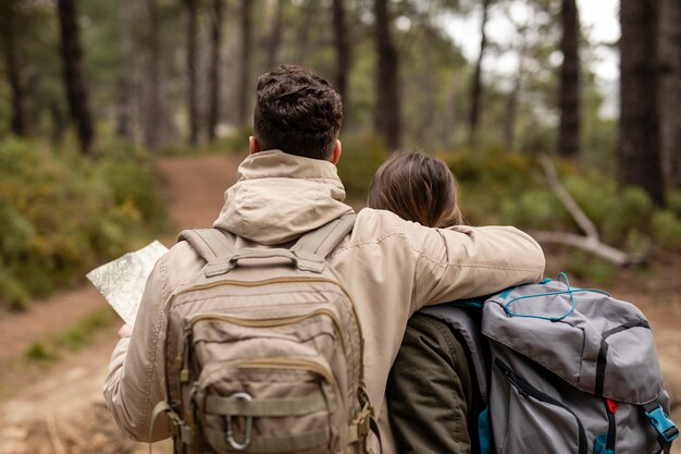 Vista posterior de personas con mochilas en la naturaleza