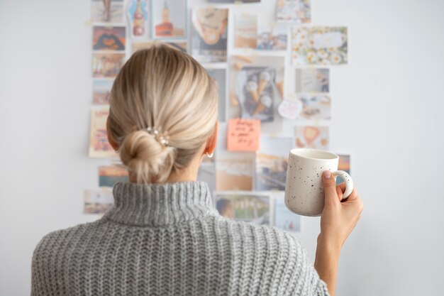 Vista posterior de la taza de café de explotación de mujer