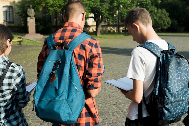 Vista posterior de tiro medio de estudiantes de secundaria leyendo