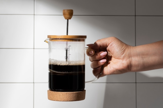 Vista de la prensa francesa para café con taza de madera.