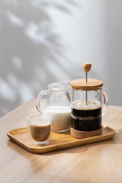 Foto gratuita vista de la prensa francesa para café con taza de madera.