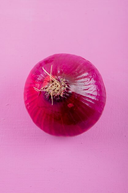 Vista de primer plano de cebolla roja sobre fondo morado con espacio de copia