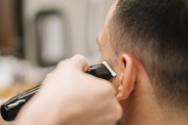 Vista de primer plano de hairstilyst dando un corte de pelo