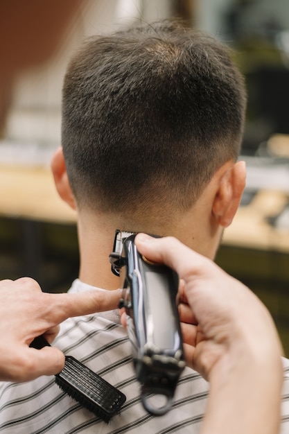 Vista de primer plano de hairstilyst dando un corte de pelo