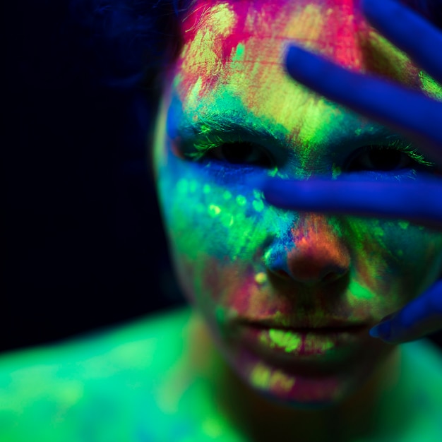 Foto gratuita vista de primer plano de mujer con colorido maquillaje fluorescente