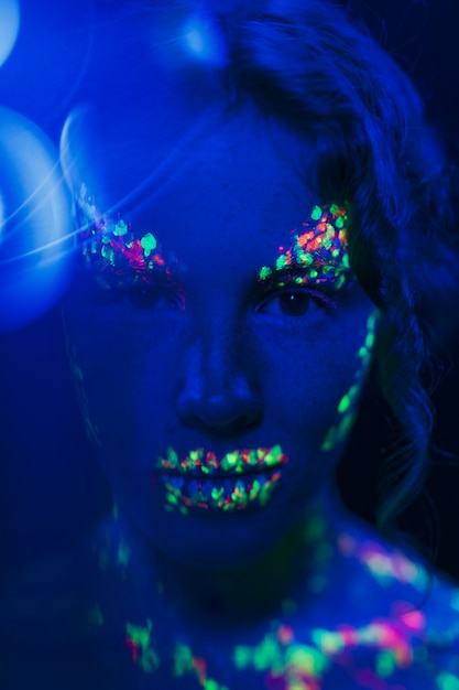 Vista de primer plano de mujer con colorido maquillaje fluorescente