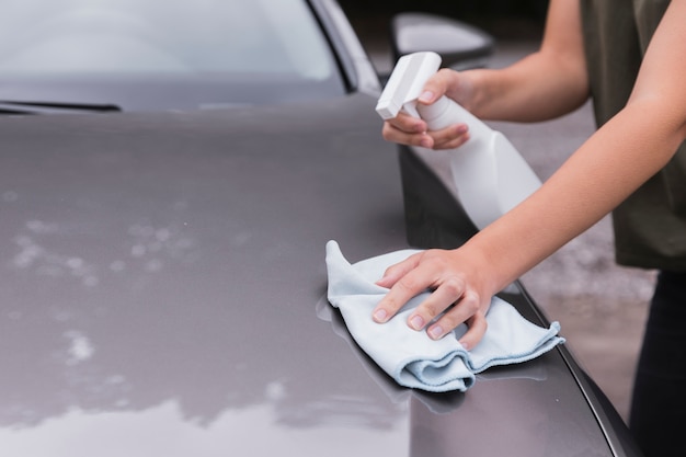 Vista de primer plano con una mujer limpiando el coche