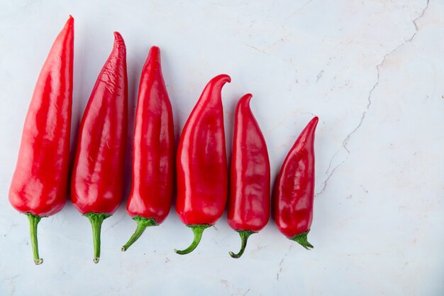 Vista de primer plano de pimientos rojos en el lado izquierdo y fondo blanco con espacio de copia