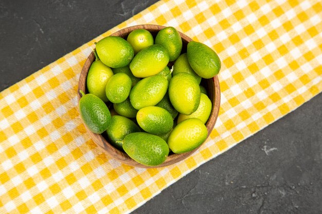 Vista de primer plano superior frutas frutas sobre el mantel blanco-amarillo en el centro de la mesa