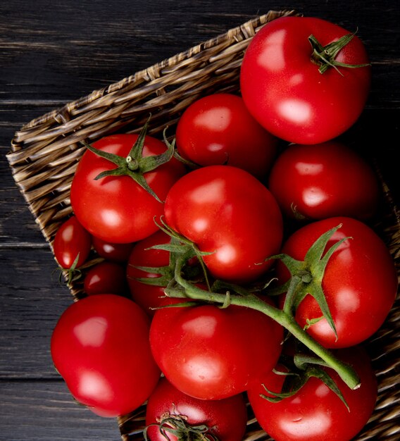 Vista de primer plano de tomates en el plato de la cesta en la mesa de madera