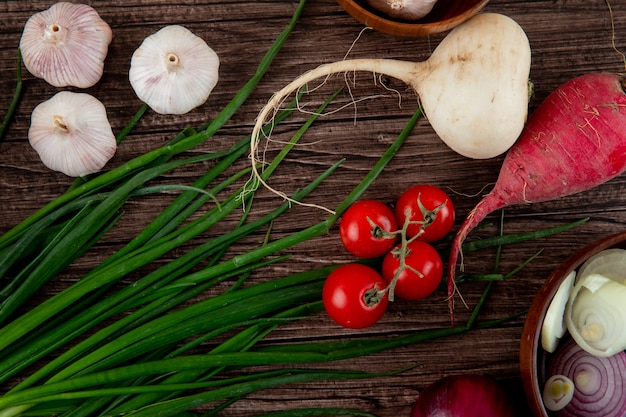 Foto gratuita vista de primer plano de verduras como tomate ajo rábano cebolla sobre fondo de madera