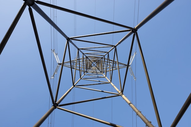 Vista de rana de un poste eléctrico contra un cielo azul claro