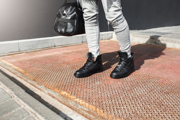 Vista recortada de pies de hombre con botas de cuero de moda