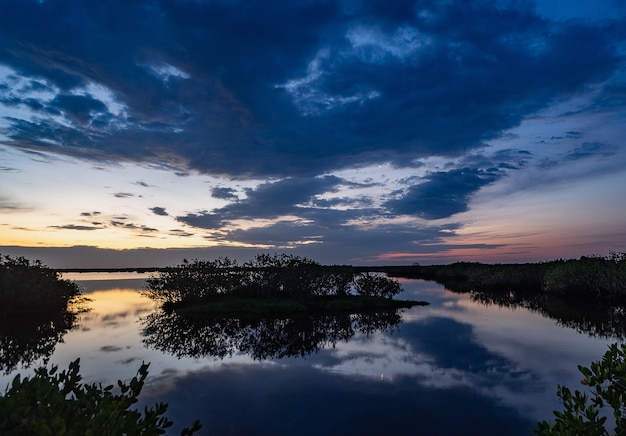 Vista del reflejo del cielo en el lago con manglares en la Costa Espacial de Florida al amanecer.