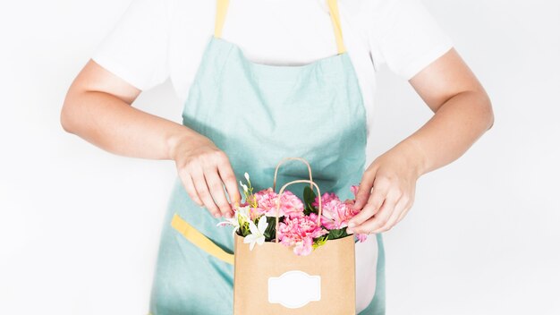 Vista de la sección media de una mano femenina con bolsa de papel de flores