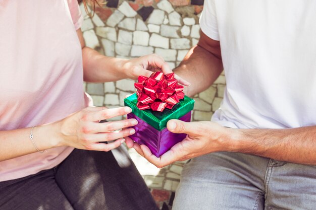 Vista de la sección media de la mano de un par de caja de regalo