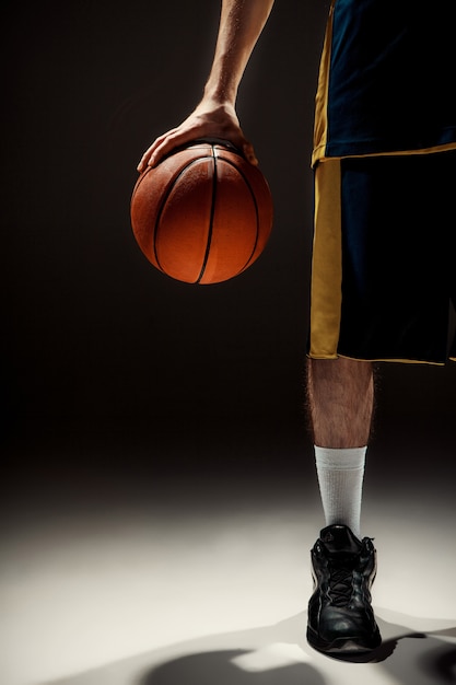 Vista de la silueta de un jugador de baloncesto con baloncesto sobre fondo negro